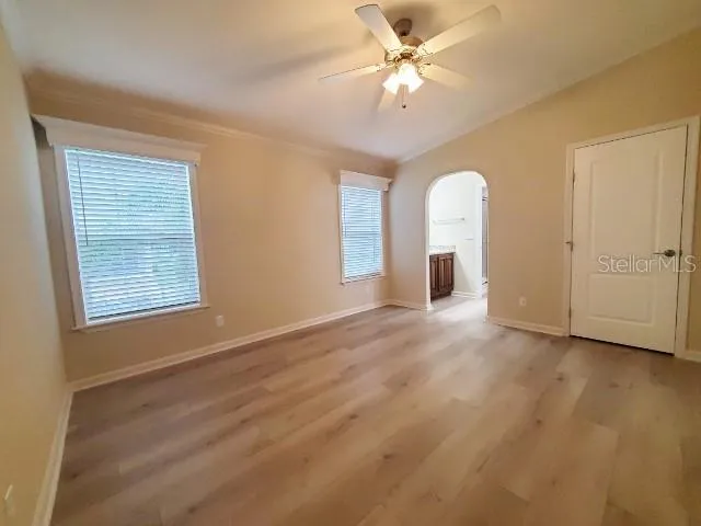 a view of an empty room with a window and kitchen view