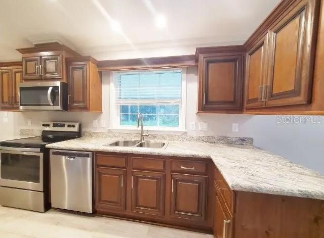 a kitchen with granite countertop a sink and a refrigerator