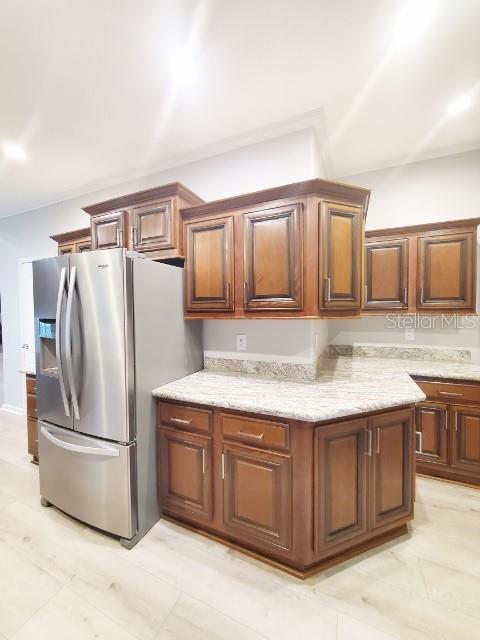 12116 Southwest County 769 Rd Lake, Unit 121 Lake Suzy, FL 34269 - Photo 33 of 45 a kitchen with granite countertop a sink and a refrigerator