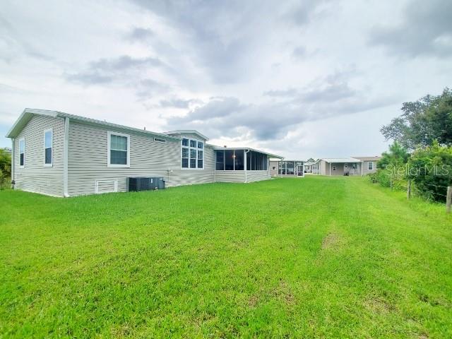 12116 Southwest County 769 Rd Lake, Unit 121 Lake Suzy, FL 34269 - Photo 41 of 45 a view of house with yard and green space