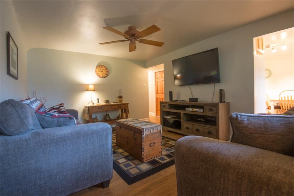 15x11 living room with hardwood floors, fresh paint, and newer ceiling fan.  