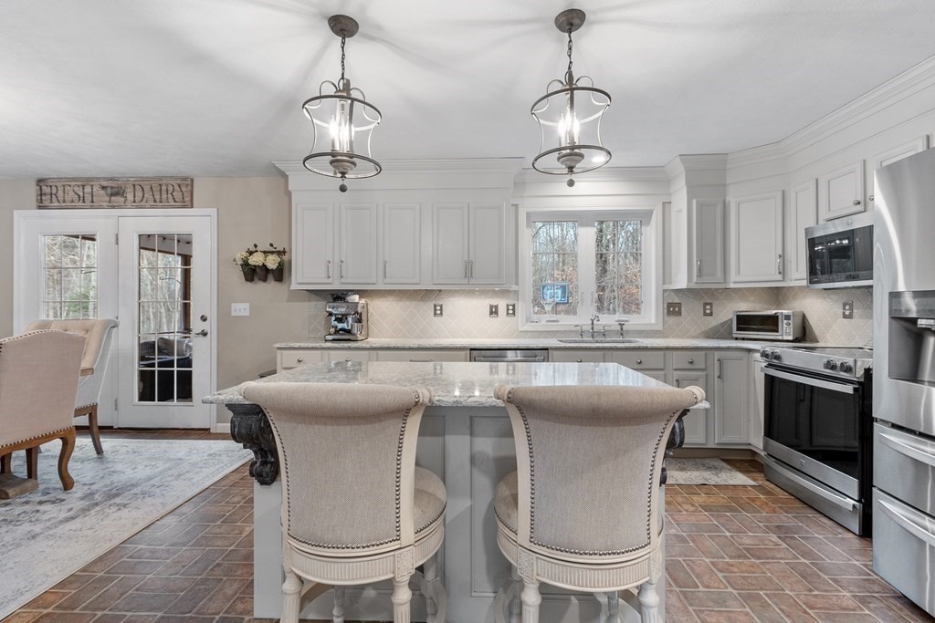 41 Willard Road Ashburnham, MA 01430 - Photo 3 of 42 a kitchen with stainless steel appliances granite countertop a sink a stove a dining table and chairs