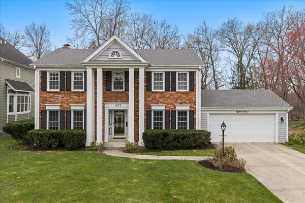 a front view of a house with a yard garage and outdoor seating