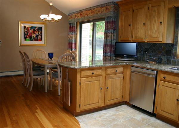 179 Littleton Road Harvard, MA 01451 - Photo 18 of 27 a kitchen with stainless steel appliances granite countertop a stove a sink a dining table and chairs with wooden floor