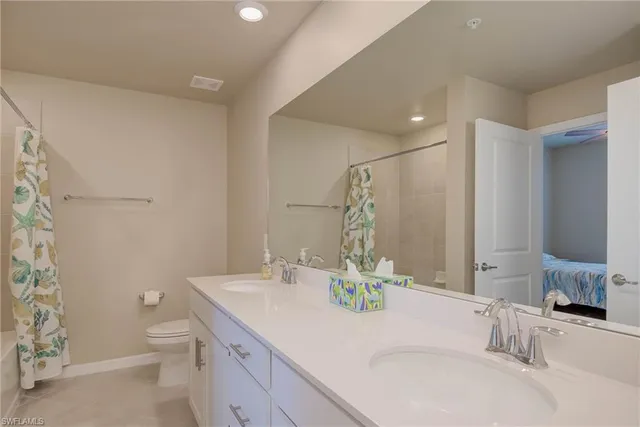 a bathroom with a granite countertop sink a toilet and a mirror