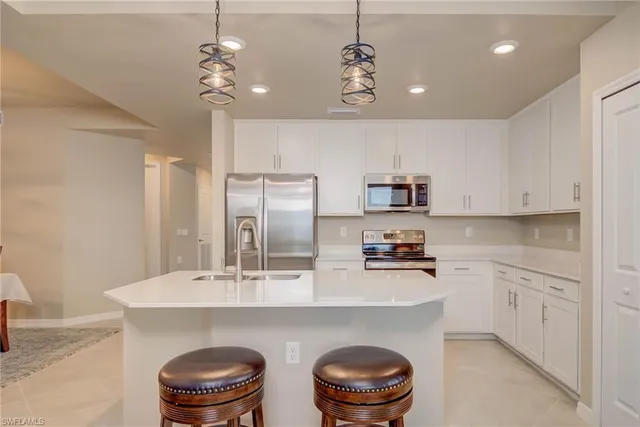 a kitchen with stainless steel appliances granite countertop a sink a stove and refrigerator