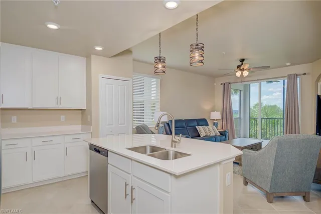 a view of a kitchen counter space a sink wooden floor and windows