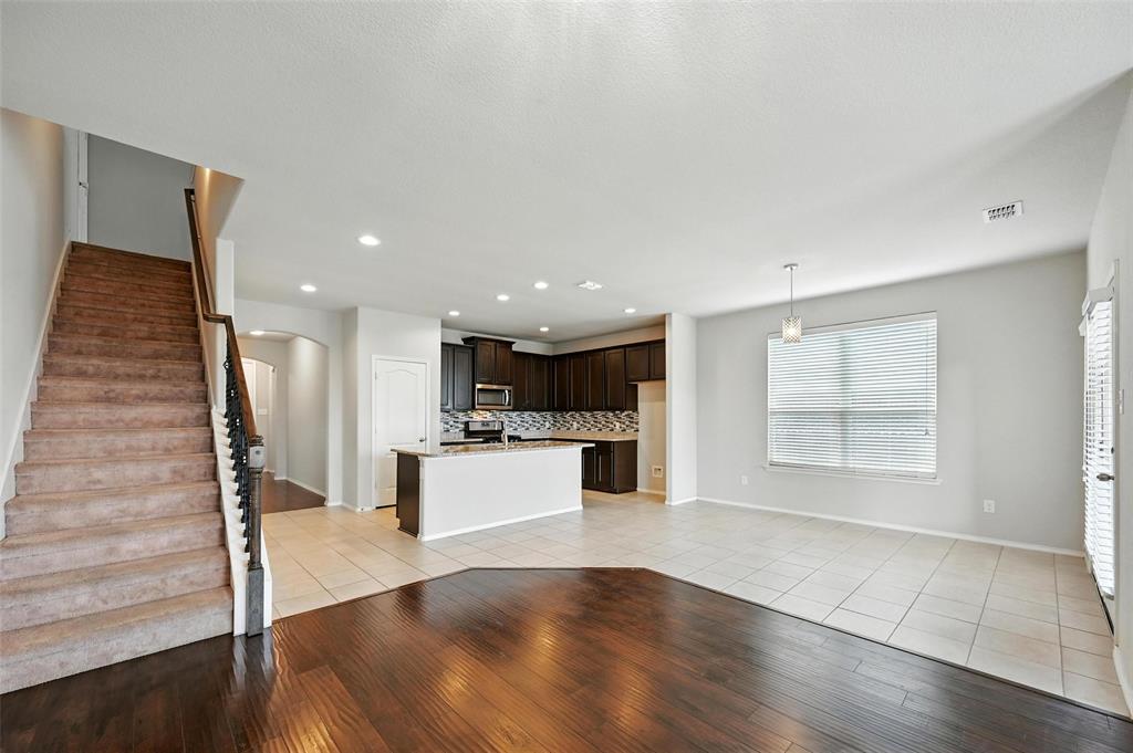 1724 Long Meadow Road Wylie, TX 75098 - Photo 4 of 23 a living room with stainless steel appliances kitchen island hardwood floor sink stove and kitchen view