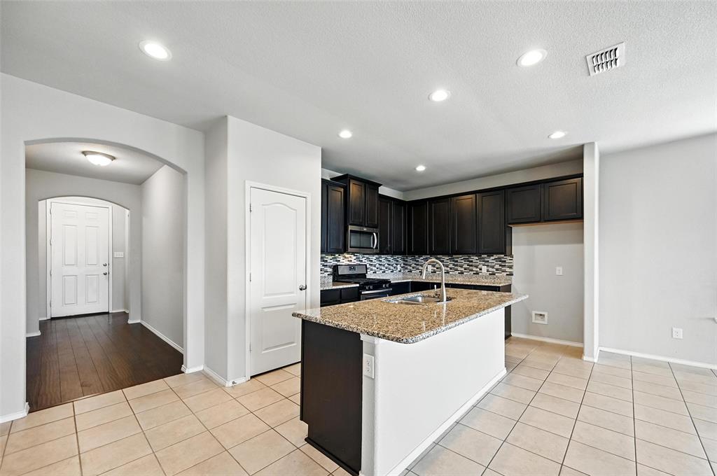1724 Long Meadow Road Wylie, TX 75098 - Photo 8 of 23 a kitchen with stainless steel appliances granite countertop a sink and a stove with wooden floor