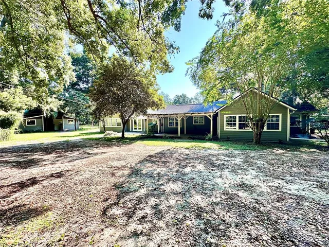 a view of a house with a yard and sitting area
