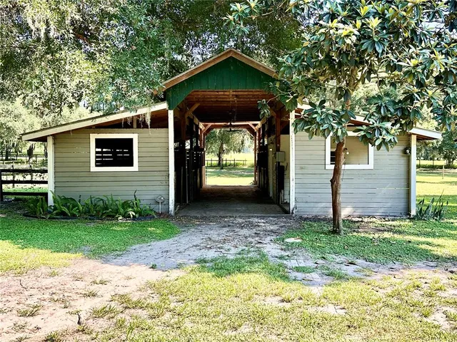 a view of a house with a big yard and large trees