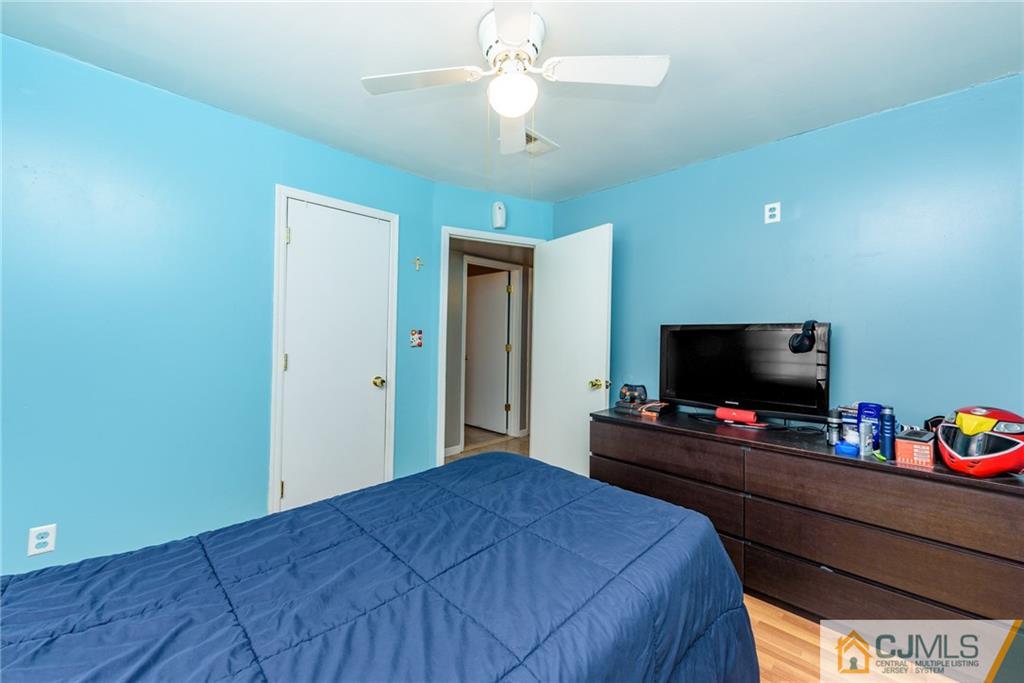 61 Gurley Road Edison, NJ 08817 - Photo 13 of 21 a bedroom with a bed and a flat tv screen on dresser