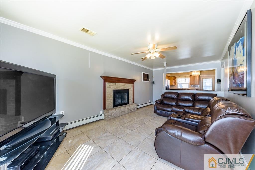 61 Gurley Road Edison, NJ 08817 - Photo 3 of 21 a living room with furniture a fireplace and a flat screen tv