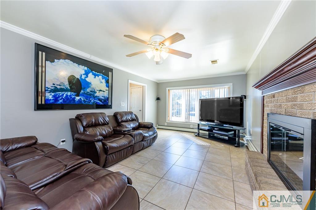 61 Gurley Road Edison, NJ 08817 - Photo 4 of 21 a living room with furniture a flat screen tv and a fireplace