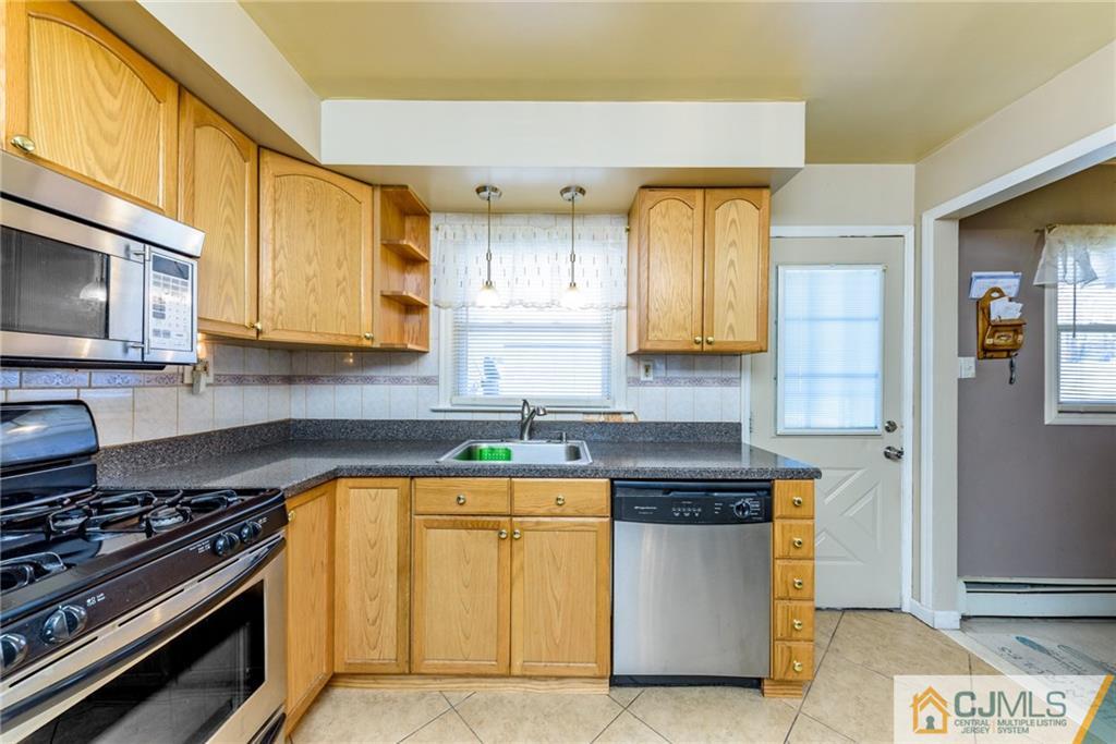 61 Gurley Road Edison, NJ 08817 - Photo 7 of 21 a kitchen with stainless steel appliances granite countertop a stove a sink and a microwave
