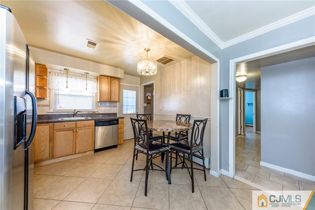 61 Gurley Road Edison, NJ 08817 - Photo 8 of 21 a kitchen with a dining table chairs and refrigerator