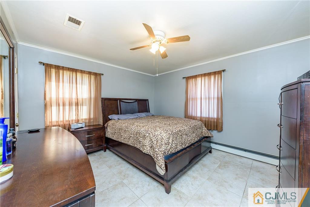 61 Gurley Road Edison, NJ 08817 - Photo 10 of 21 a bedroom with a large bed and a chandelier