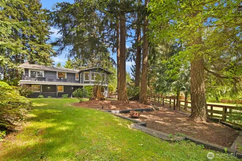 a view of a house with a big yard and large trees