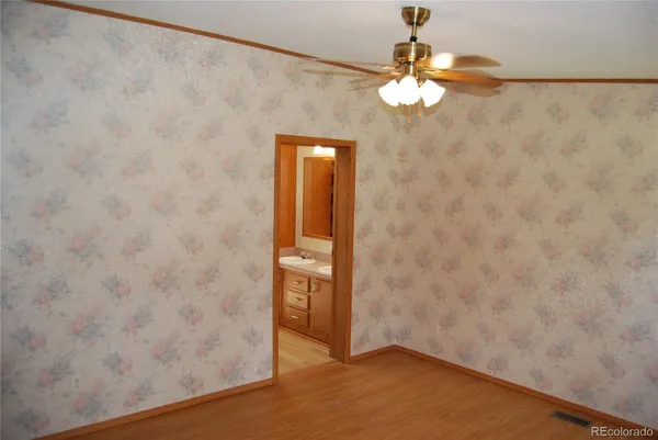a view of a small space with wooden floor and a window