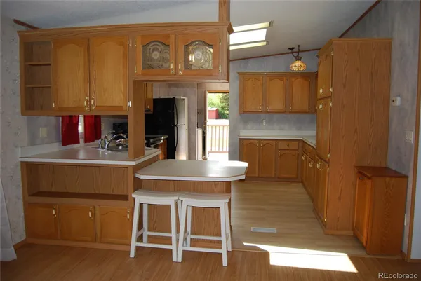 a kitchen with a table chairs refrigerator and cabinets