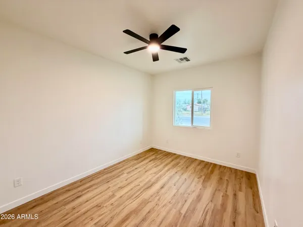 a view of empty room with wooden floor