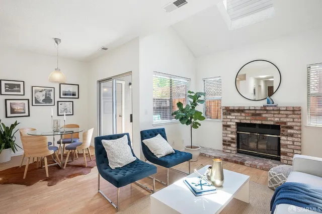 a living room with furniture a fireplace and a large mirror