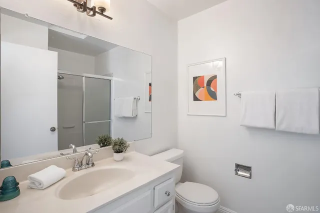 a bathroom with a sink vanity mirror and toilet