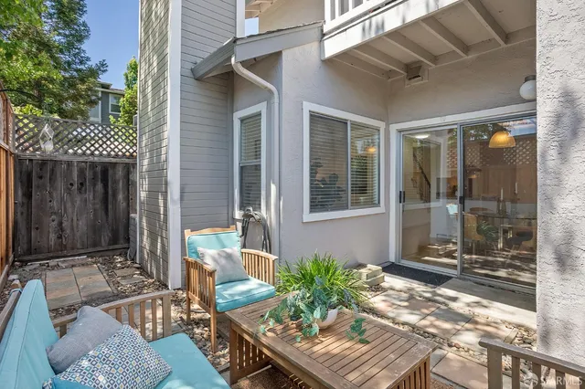 a view of backyard with outdoor seating and wooden fence