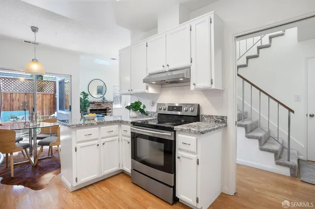 a kitchen with a stove and white cabinets