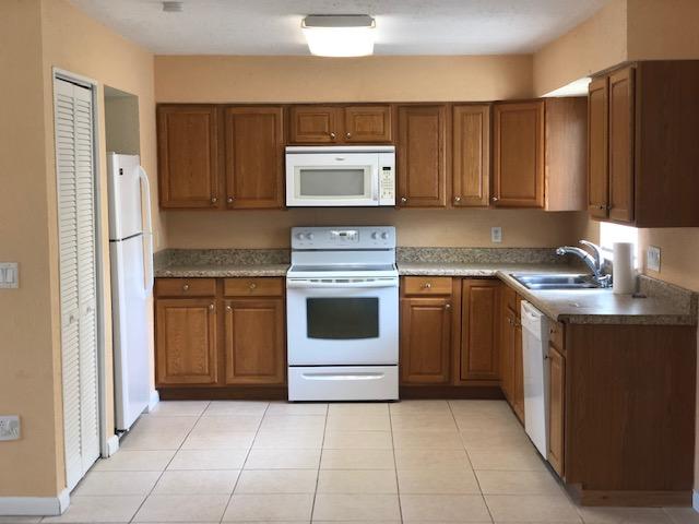 7407 Sebastian Road Fort Pierce, FL 34951 - Photo 5 of 13 a kitchen with a stove sink and a refrigerator