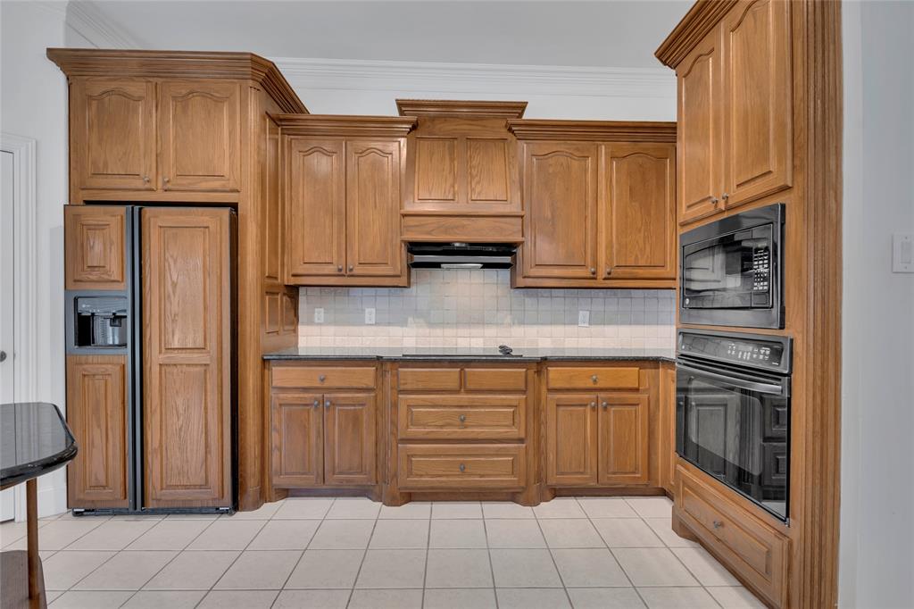1714 Morrish Lane Heath, TX 75032 - Photo 12 of 33 a kitchen with stainless steel appliances granite countertop a refrigerator and cabinets