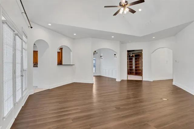 a view of an empty room with window and wooden floor