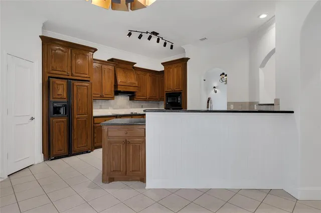 a kitchen with stainless steel appliances granite countertop a refrigerator and a stove top oven