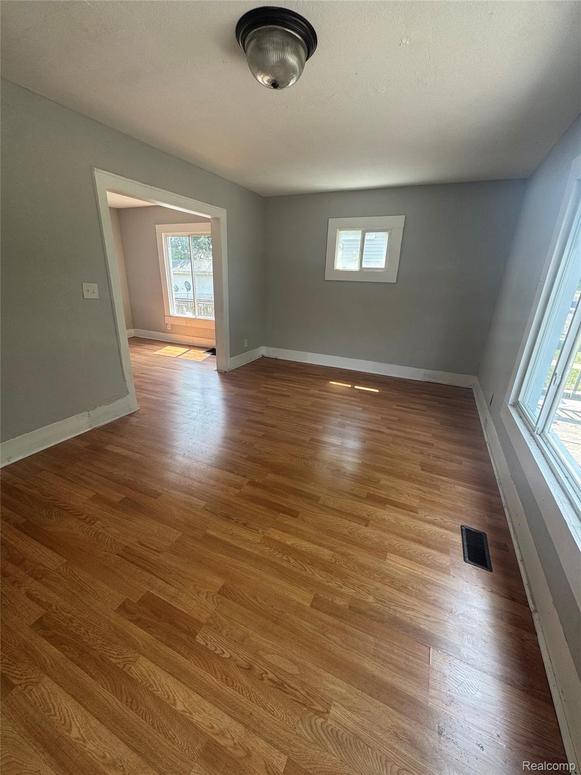 2176 Springle Street Detroit, MI 48215 - Photo 2 of 9 Spacious room featuring wood-finish flooring, light gray wall paint, and white trim
