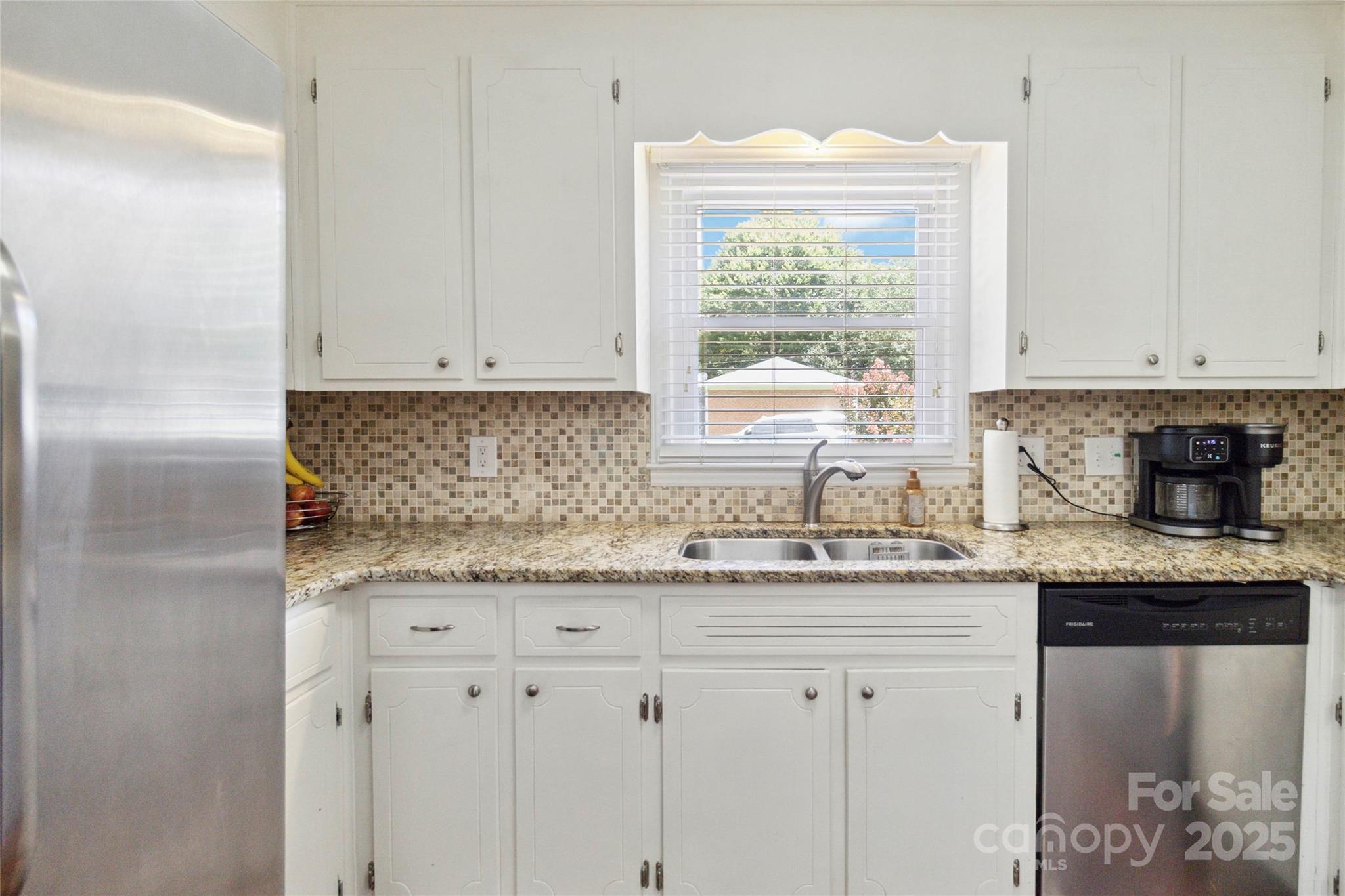 1219 Flowe Drive Matthews, NC 28104 - Photo 9 of 30 a kitchen with granite countertop white cabinets and window