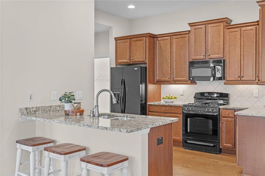 2716 Grapevine Circle Cumming, GA 30041 - Photo 12 of 37 a kitchen with stainless steel appliances granite countertop a stove a sink dishwasher and a refrigerator