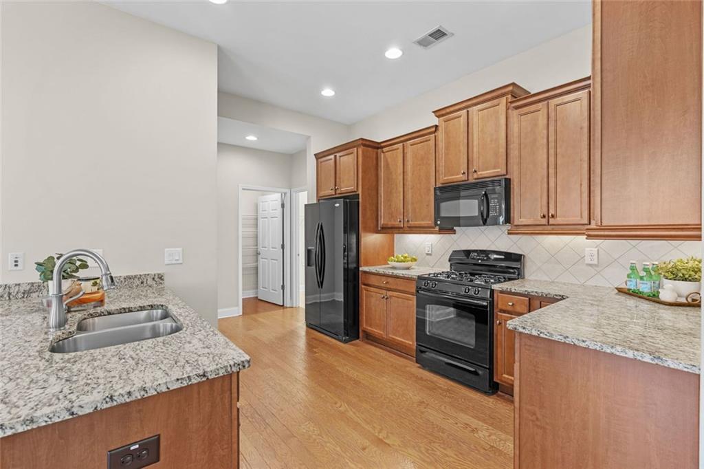 2716 Grapevine Circle Cumming, GA 30041 - Photo 14 of 37 a kitchen with stainless steel appliances granite countertop a sink stove microwave and refrigerator