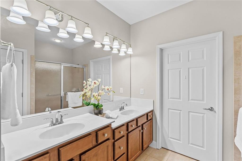 2716 Grapevine Circle Cumming, GA 30041 - Photo 24 of 37 a bathroom with a double vanity sink and a mirror