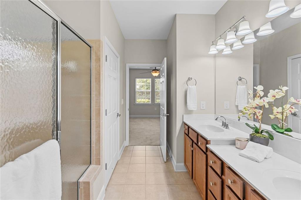 2716 Grapevine Circle Cumming, GA 30041 - Photo 25 of 37 a spacious bathroom with a granite countertop sink a mirror and a shower