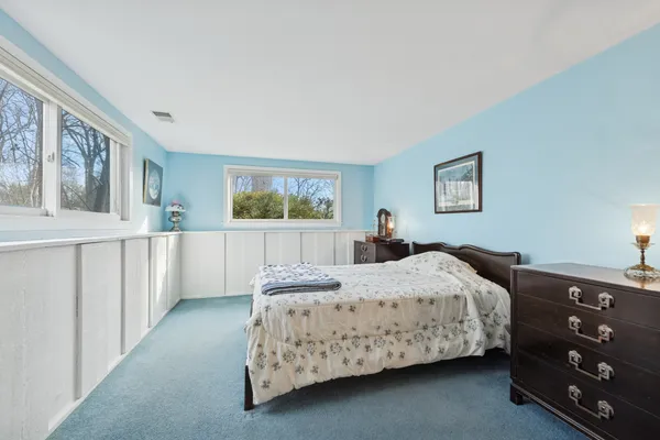 a bedroom with a bed a lamp and window