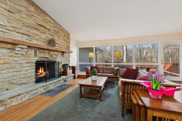 a living room with furniture a fireplace and a floor to ceiling window