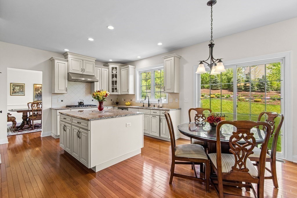 14 Pine Tree Drive Methuen, MA 01844 - Photo 13 of 42 a kitchen with stainless steel appliances granite countertop a stove a sink a refrigerator a dining table and chairs with wooden floor