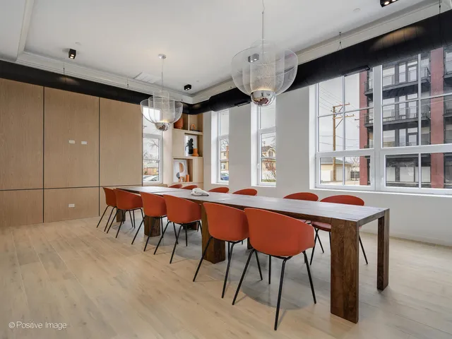 a dining room with stainless steel appliances kitchen island granite countertop a table chairs and a refrigerator