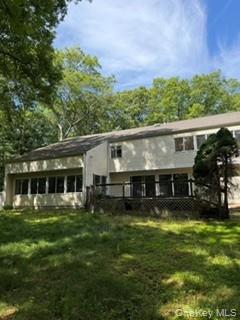 a view of a house with a big yard and large trees