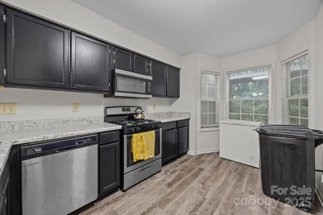 a kitchen with granite countertop stainless steel appliances and wooden cabinets
