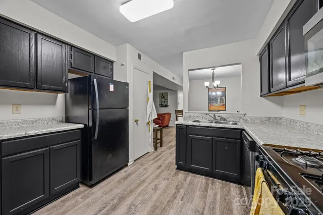 a kitchen with stainless steel appliances granite countertop a stove refrigerator and cabinets