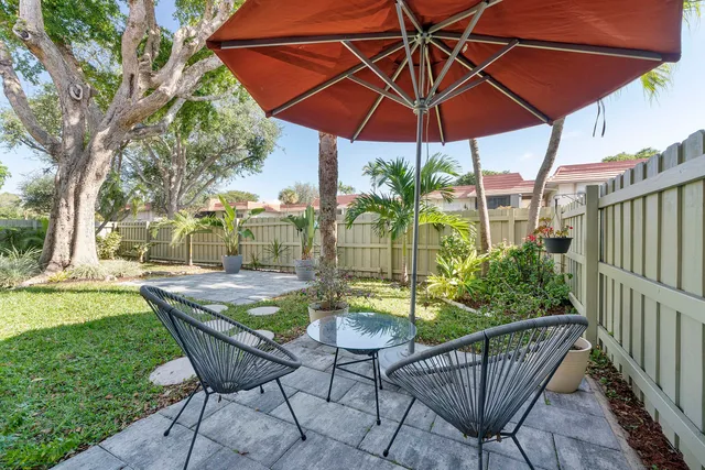 a view of an outdoor sitting area with furniture and umbrella