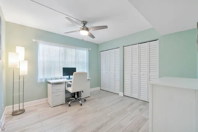 a view of a workspace with furniture and a window