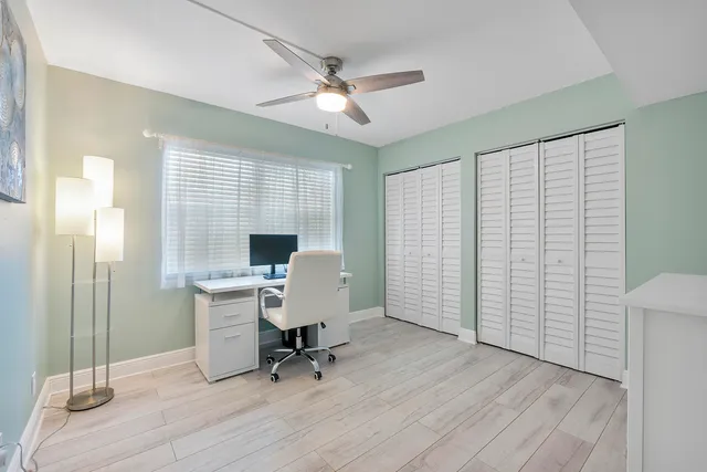 a view of a workspace with furniture and a window