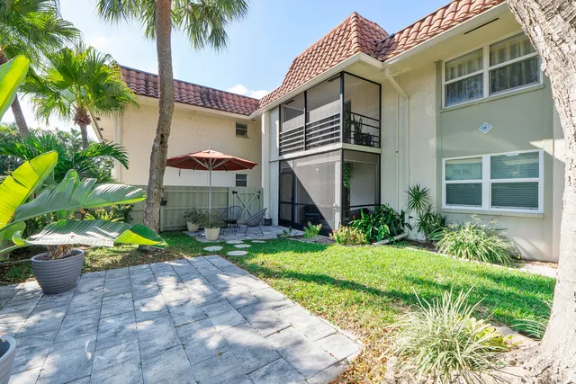 a front view of a house with a yard and potted plants